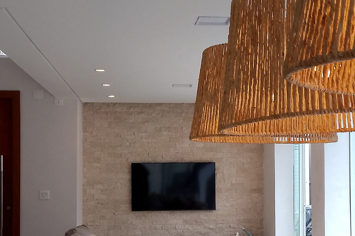 Estar com painel de mármore e pendentes de palha